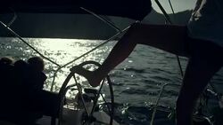 Woman steers the yacht with leg Stock Footage