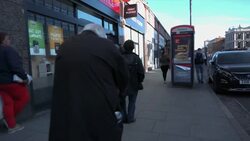 Shots of a long queue waiting to enter the Post Office in Camden during the UK Lockdown News Clip