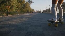 Young stylish attractive woman skateboarding at sunrise on seafront, slow motion, close up shot Stock Footage