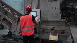 Worker at waste disposal dump controlling conveyor belt speed on touch screen Stock Footage