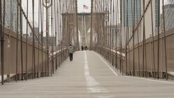 Person walks the Brooklyn Bridge News Clip