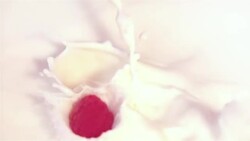 Raspberries falling into milk in slow motion 250fps Stock Footage