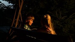 Kids having fun on swing, little gentleman carefully hugging girl by shoulders Stock Footage