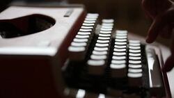 Side shot of a person writing on an old typewriter, with sound... Stock Footage
