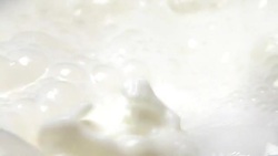 Close-up milky liquid boil up in slow motion Stock Footage