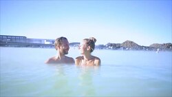 Geothermal spa. Young couple relaxing in hot spring pool in Iceland. people enjoying bathing in a blue water lagoon Icelandic tourist attraction, Video SLOW MOTION Stock Footage