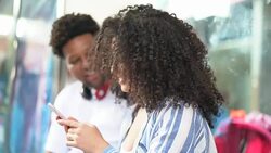 Young Couple Using Mobile at Bus Station Stock Footage
