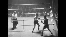 Boxing match between Charlie Hill and Billy Kelly ends with Hill's win and spectators throwing chairs News Clip