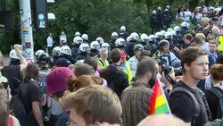 Crowd of demonstrators and line of riot police standing off against protestors News Clip