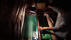 Craftsman working on huge old wooden brocade weaving looms Stock Footage
