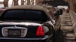 MEDIUM ANGLE OF BLACK LIMO DRIVING ACROSS STEEL BEAM BRIDGE. SEE NEW YORK LICENSE PLATES AS CARS, JEEPS, AND TAXIS DRIVE AWAY FROM CAMERA. COULD BE OVER HUDSON OR EAST RIVERS. MANHATTAN. Stock Footage