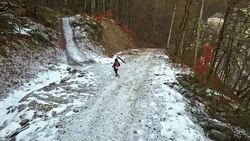 young man walking on a snowy mountain road on a winter day Stock Footage