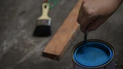 The human hand is stirring color in can Stock Footage