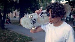 skateboarder walking through the public park Stock Footage