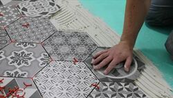 man laying hexagon floor tiles Stock Footage